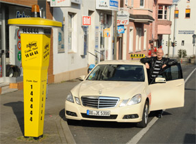 Taxifahrer mit Fahrzeug neben Rufsäle